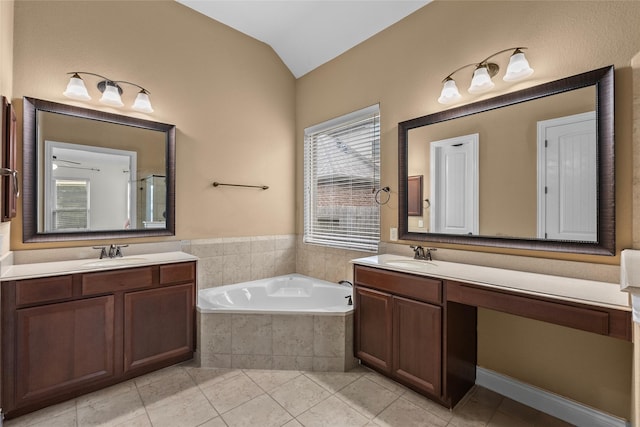 321 Westwood Dr, League City, TX 77573 - bathroom featuring vaulted ceiling, a bath, two vanities, and tile patterned flooring