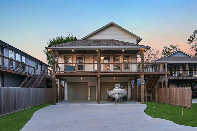 view of front of house with concrete driveway, fence, a garage, and stairs