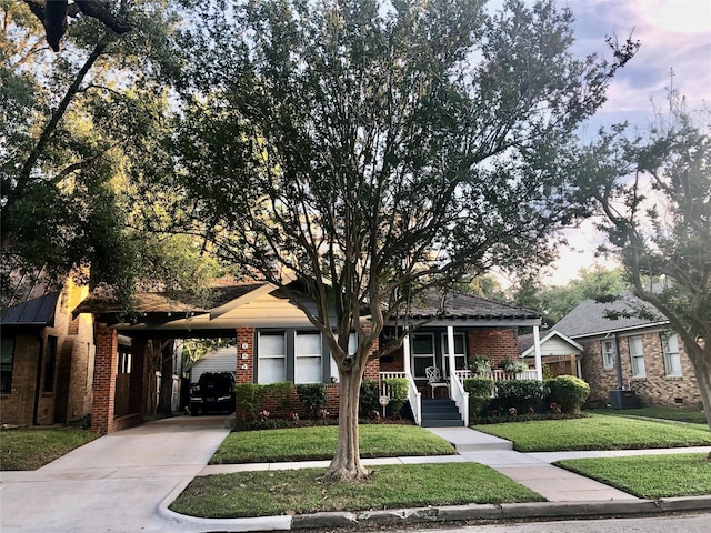 824 Sledge St, Houston, TX 77009 - view of front of property featuring brick siding, concrete driveway, a front lawn, covered porch, and an attached carport