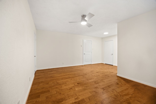 unfurnished room with light wood finished floors, ceiling fan, and baseboards