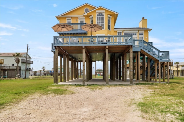 13213 Gulf Beach Dr, Freeport, TX 77541 - back of house featuring a chimney, a deck, a carport, stairway, and a yard