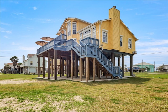 13213 Gulf Beach Dr, Freeport, TX 77541 - back of house with a patio area, a yard, a chimney, and a deck