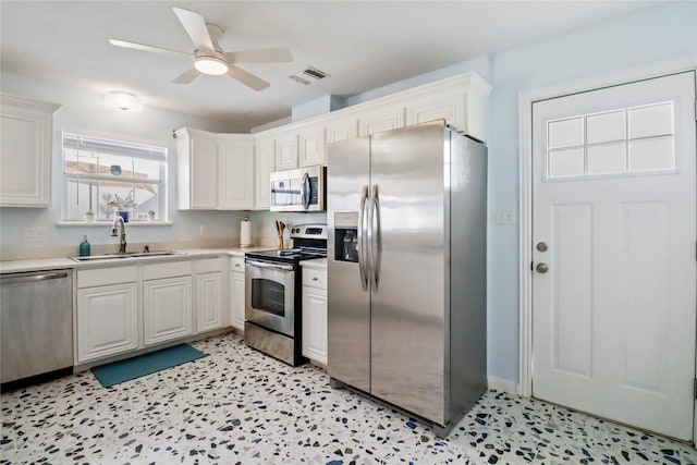kitchen featuring visible vents, light countertops, white cabinetry, a sink, and stainless steel appliances