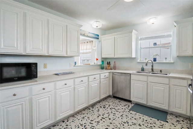 kitchen with white cabinets, black microwave, a sink, light countertops, and stainless steel dishwasher
