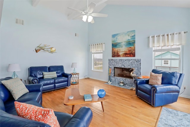 living area featuring visible vents, a fireplace, high vaulted ceiling, a ceiling fan, and light wood finished floors