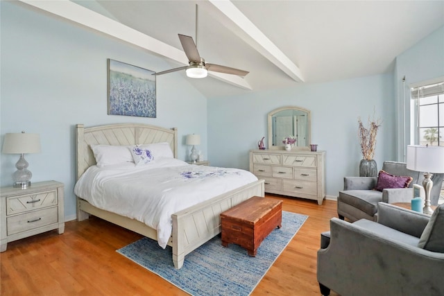 bedroom with ceiling fan, vaulted ceiling with beams, and wood finished floors