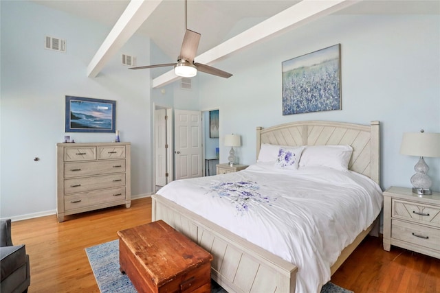 bedroom featuring visible vents, lofted ceiling, and light wood-type flooring