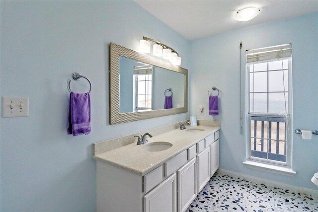 13213 Gulf Beach Dr, Freeport, TX 77541 - bathroom featuring double vanity, baseboards, and a sink