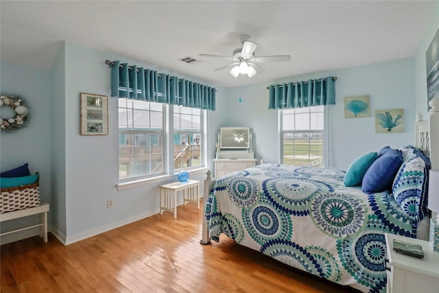 bedroom with visible vents, baseboards, ceiling fan, and wood finished floors