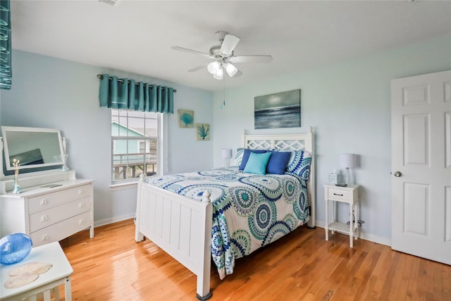bedroom with light wood-style floors, a ceiling fan, and baseboards