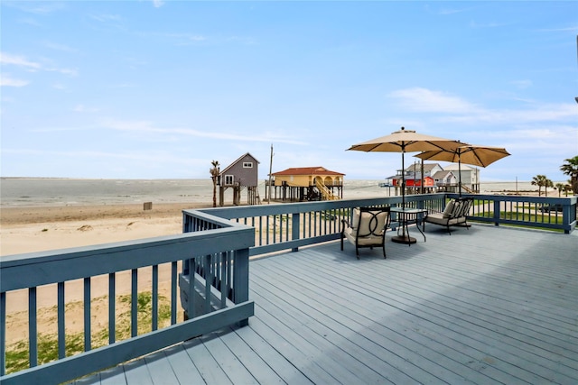 wooden deck with a view of the beach and a water view