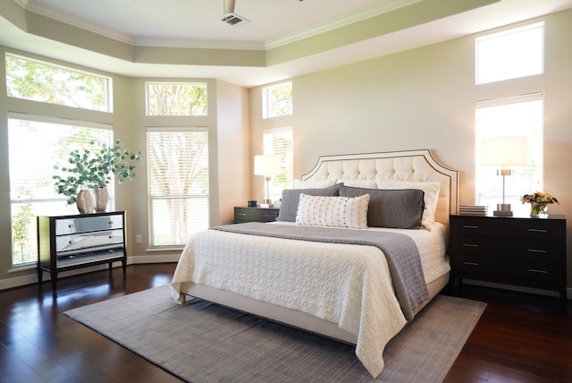 bedroom with dark wood-style flooring, multiple windows, ornamental molding, and visible vents