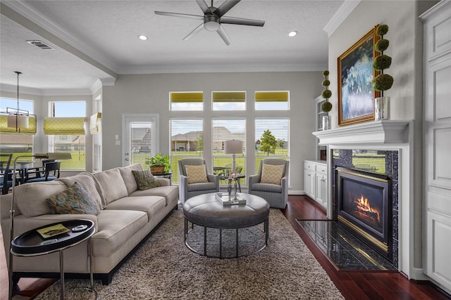 living area featuring a premium fireplace, a ceiling fan, dark wood finished floors, and visible vents
