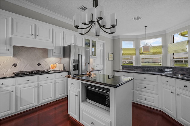 kitchen with gas stovetop, visible vents, a chandelier, high end refrigerator, and a sink
