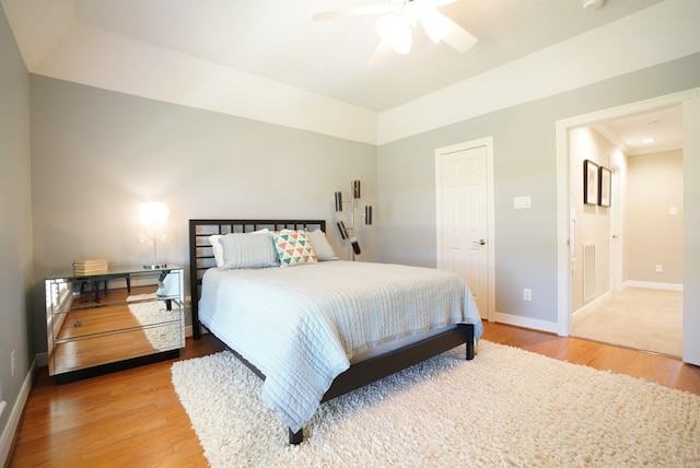 bedroom featuring ceiling fan, baseboards, ensuite bathroom, and wood finished floors