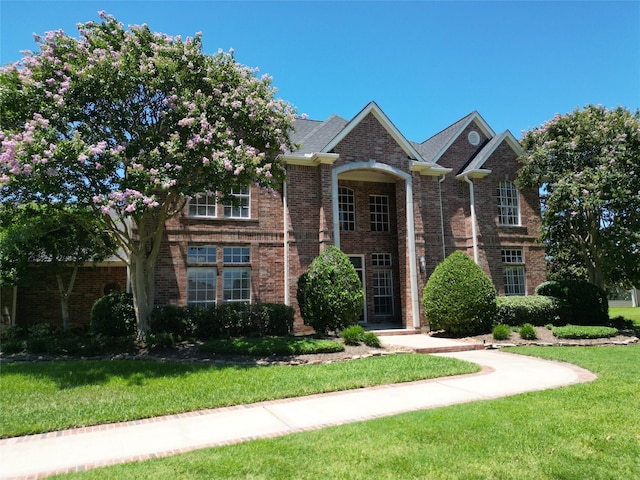 view of front of property with a front yard and brick siding