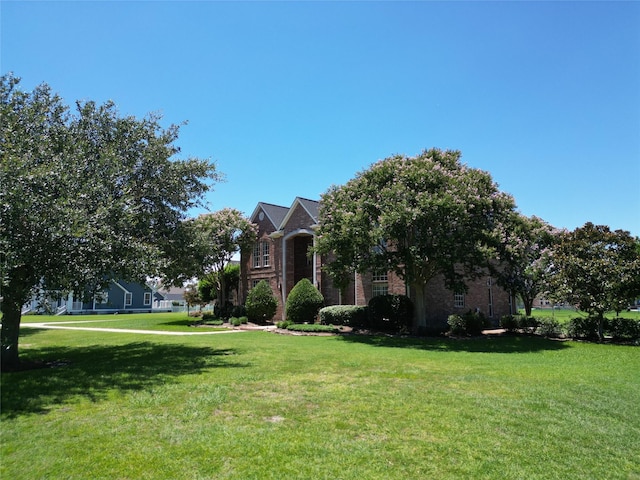 view of front of property featuring brick siding and a front lawn