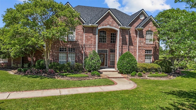 traditional home with a front lawn and brick siding