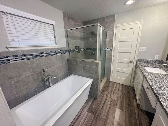 3060 Noble St, Houston, TX 77026 - bathroom featuring a soaking tub, a textured ceiling, vanity, wood finished floors, and a stall shower