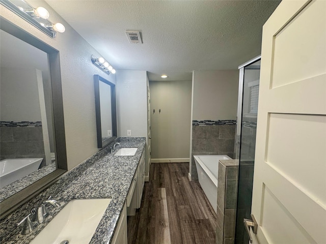 3060 Noble St, Houston, TX 77026 - bathroom with a bath, visible vents, a sink, and wood finished floors