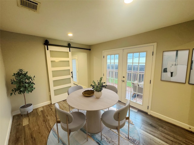 3060 Noble St, Houston, TX 77026 - dining room with visible vents, a barn door, wood finished floors, french doors, and baseboards