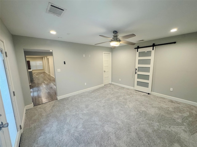 3060 Noble St, Houston, TX 77026 - carpeted spare room with visible vents, baseboards, a barn door, a ceiling fan, and recessed lighting