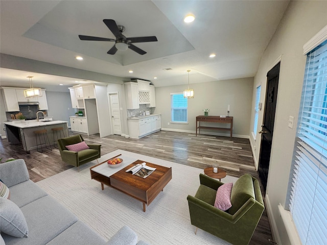 3060 Noble St, Houston, TX 77026 - living room featuring baseboards, a raised ceiling, a ceiling fan, dark wood-style floors, and recessed lighting