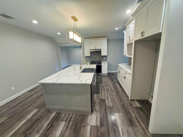 3060 Noble St, Houston, TX 77026 - kitchen featuring visible vents, a sink, dark wood-style floors, gas stove, and a center island with sink