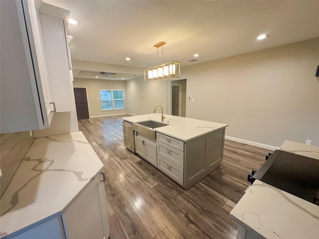 3060 Noble St, Houston, TX 77026 - kitchen featuring light stone counters, a sink, open floor plan, decorative light fixtures, and dark wood-style floors