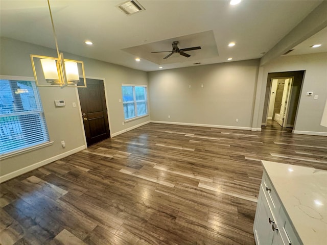 3060 Noble St, Houston, TX 77026 - unfurnished living room with visible vents, baseboards, a raised ceiling, ceiling fan, and dark wood finished floors
