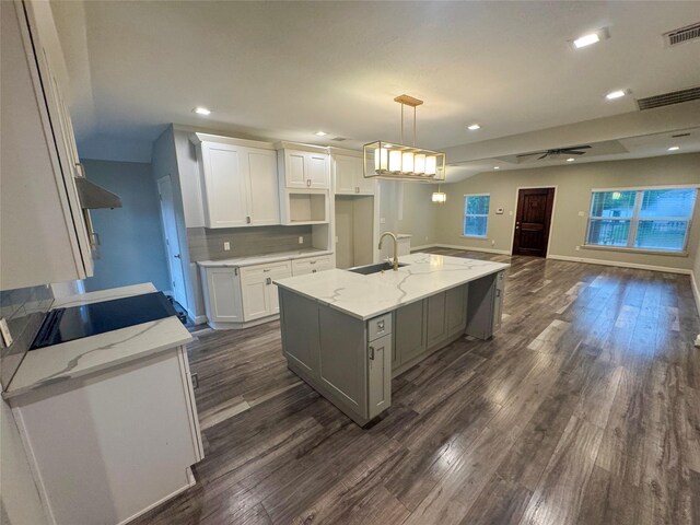 3060 Noble St, Houston, TX 77026 - kitchen featuring visible vents, white cabinets, a sink, dark wood-style flooring, and light stone countertops