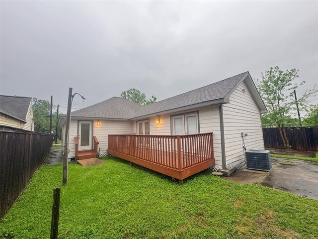 3060 Noble St, Houston, TX 77026 - back of property with central AC unit, a fenced backyard, a wooden deck, and a lawn