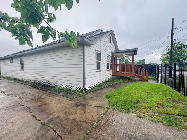 3060 Noble St, Houston, TX 77026 - view of side of home featuring a wooden deck, fence, and a lawn