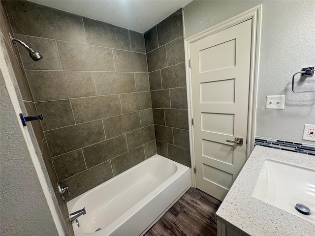 3060 Noble St, Houston, TX 77026 - bathroom featuring a textured wall, vanity, wood finished floors, and  shower combination