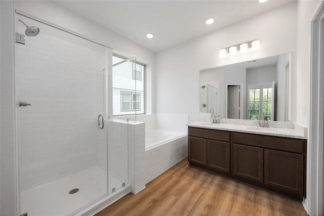 11752 Whirlaway Dr, Willis, TX 77318 - full bathroom featuring a stall shower, a garden tub, double vanity, wood finished floors, and recessed lighting