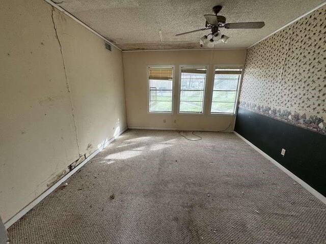 1302 S 23rd St, Temple, TX 76504 - carpeted empty room with a textured ceiling, ceiling fan, and visible vents