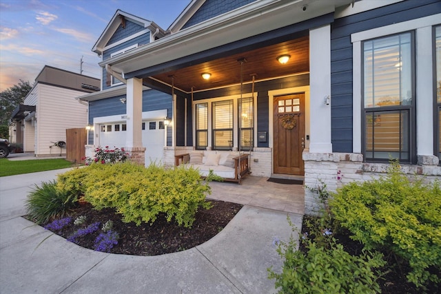 1411 Overhill St, Houston, TX 77018 - exterior entry at dusk with concrete driveway, a porch, and a garage