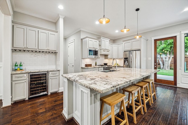 1411 Overhill St, Houston, TX 77018 - kitchen featuring dark wood finished floors, beverage cooler, recessed lighting, decorative backsplash, and appliances with stainless steel finishes