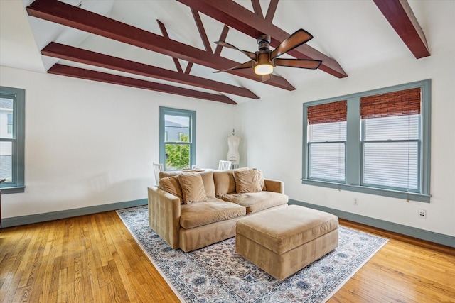 living area with a ceiling fan, baseboards, lofted ceiling with beams, and wood finished floors
