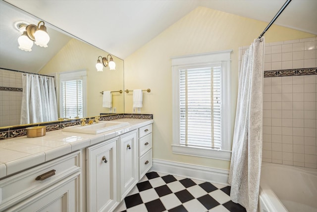 full bathroom with vanity, lofted ceiling, baseboards, tile patterned floors, and shower / bath combo