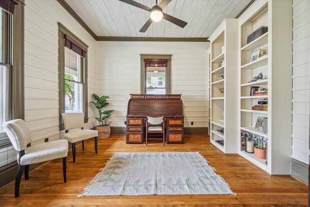living area featuring crown molding, hardwood / wood-style floors, ceiling fan, wooden walls, and wood ceiling