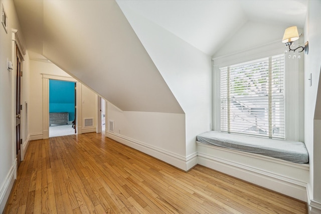 bonus room with visible vents, baseboards, lofted ceiling, and hardwood / wood-style flooring