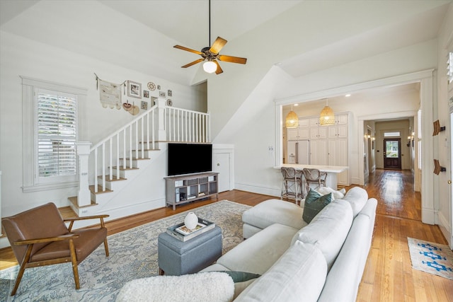 living area featuring plenty of natural light, stairs, and hardwood / wood-style floors