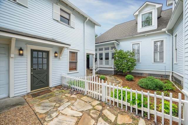 entrance to property with fence and roof with shingles