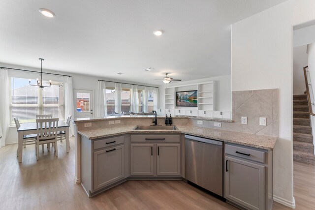 23830 Via Leoni Dr, New Caney, TX 77357 - kitchen featuring stainless steel dishwasher, a sink, a peninsula, light wood-style flooring, and recessed lighting