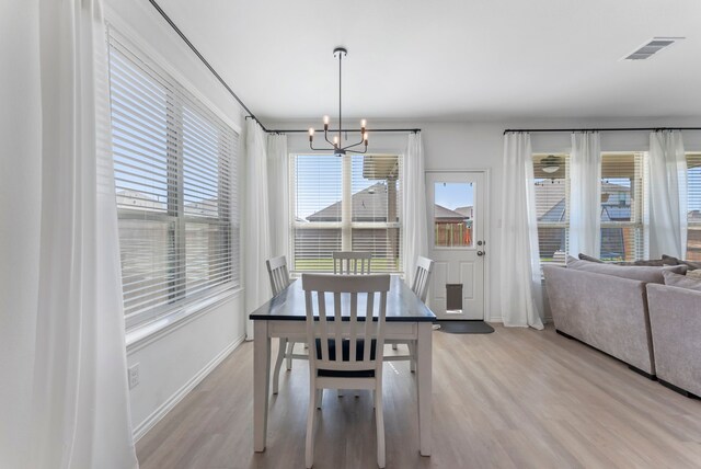 23830 Via Leoni Dr, New Caney, TX 77357 - dining space with a chandelier, light wood-type flooring, and baseboards
