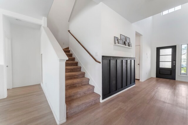 23830 Via Leoni Dr, New Caney, TX 77357 - foyer entrance with light wood finished floors, a high ceiling, stairway, and baseboards
