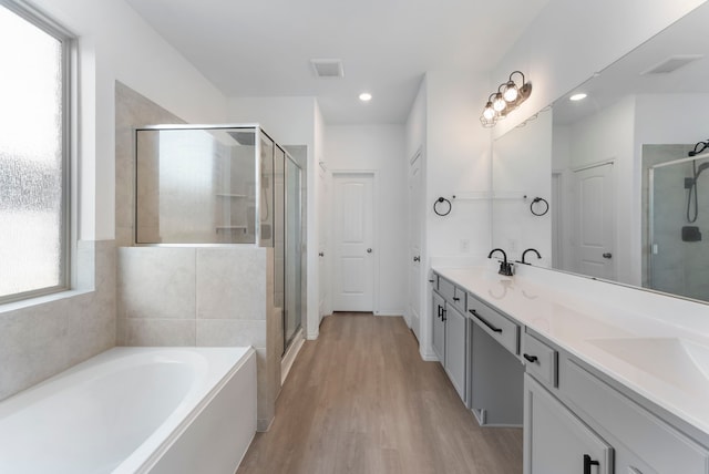 23830 Via Leoni Dr, New Caney, TX 77357 - full bath with a shower stall, wood finished floors, a bath, double vanity, and recessed lighting
