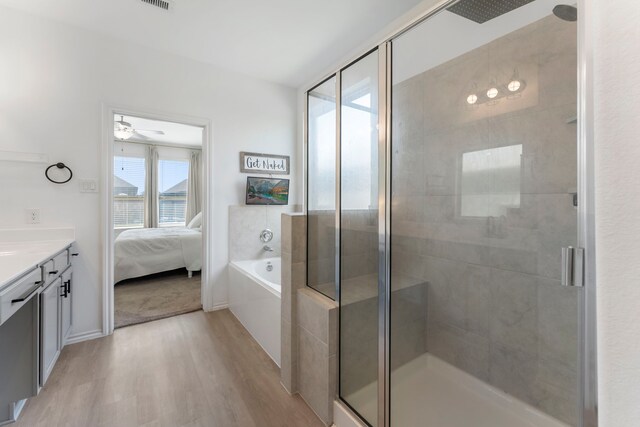 23830 Via Leoni Dr, New Caney, TX 77357 - bathroom featuring wood finished floors, a shower stall, vanity, a bath, and connected bathroom