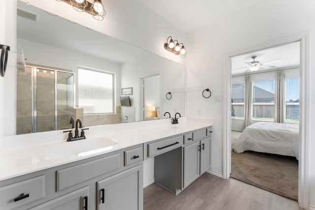 23830 Via Leoni Dr, New Caney, TX 77357 - full bathroom with a shower stall, wood finished floors, double vanity, a ceiling fan, and ensuite bathroom